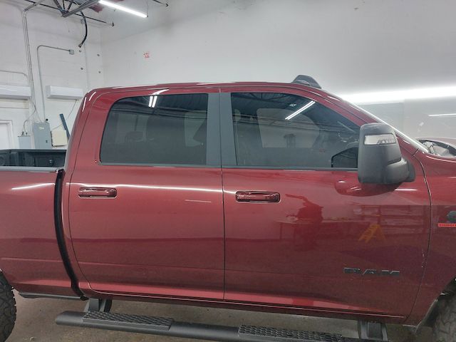 A red ram truck is parked in a garage.