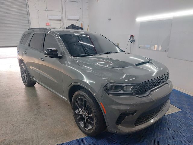 A grey dodge durango is parked in a garage.