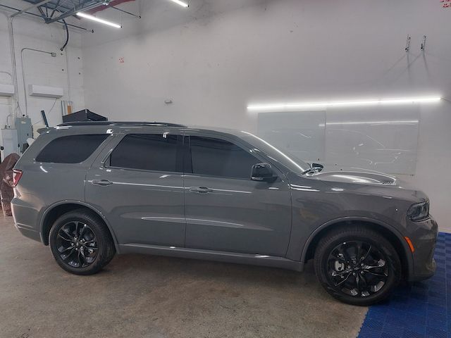 A gray dodge durango is parked in a garage.
