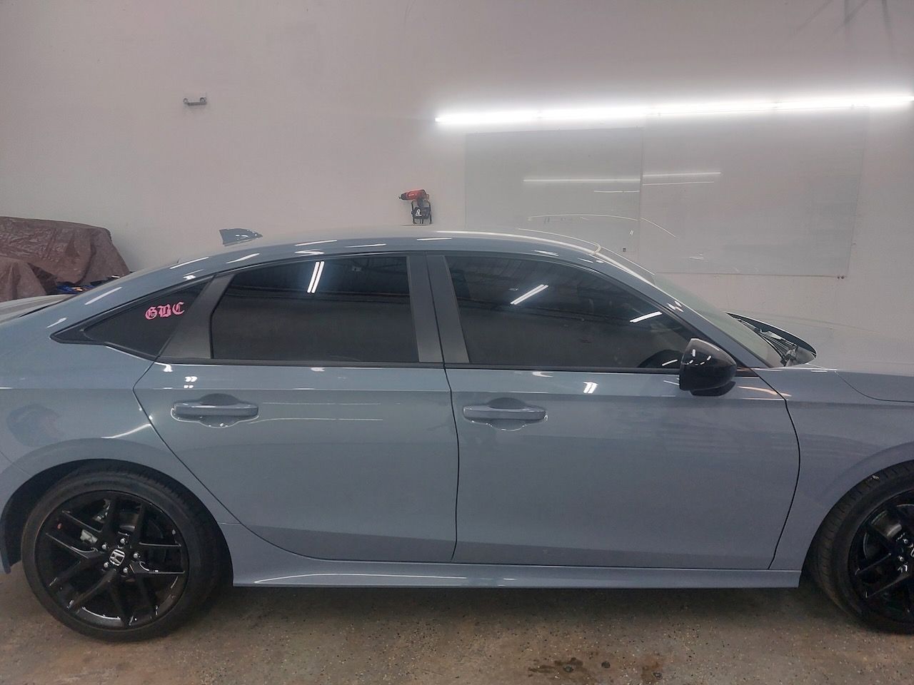 A blue honda civic is parked in a garage.