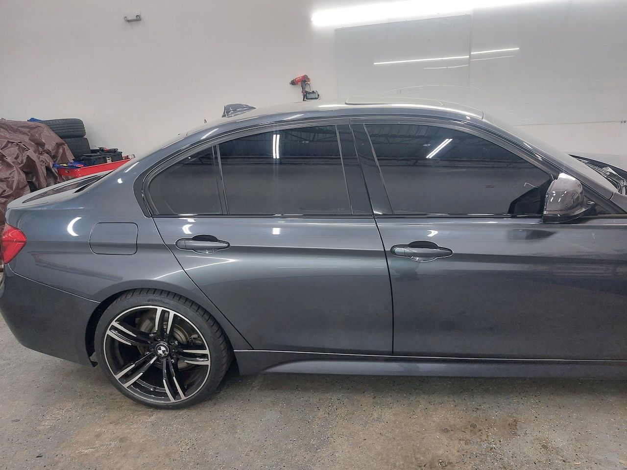 A gray car is parked in a garage.
