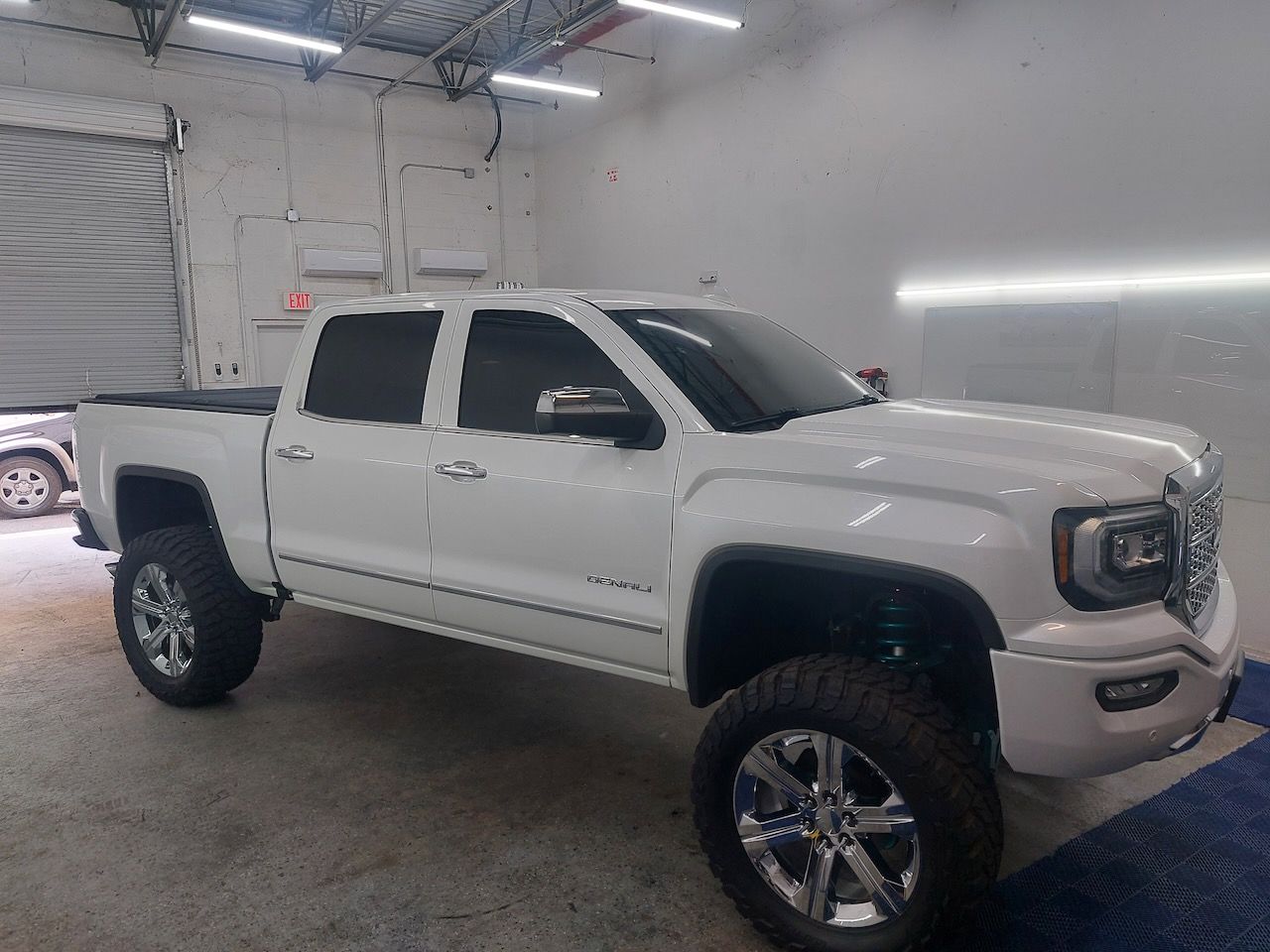 A white pickup truck is parked in a garage.