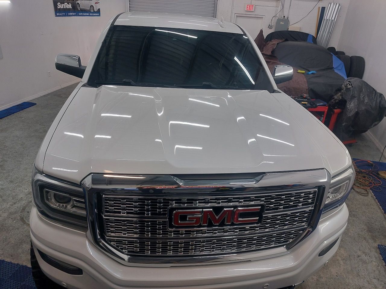 A white gmc truck is parked in a garage.