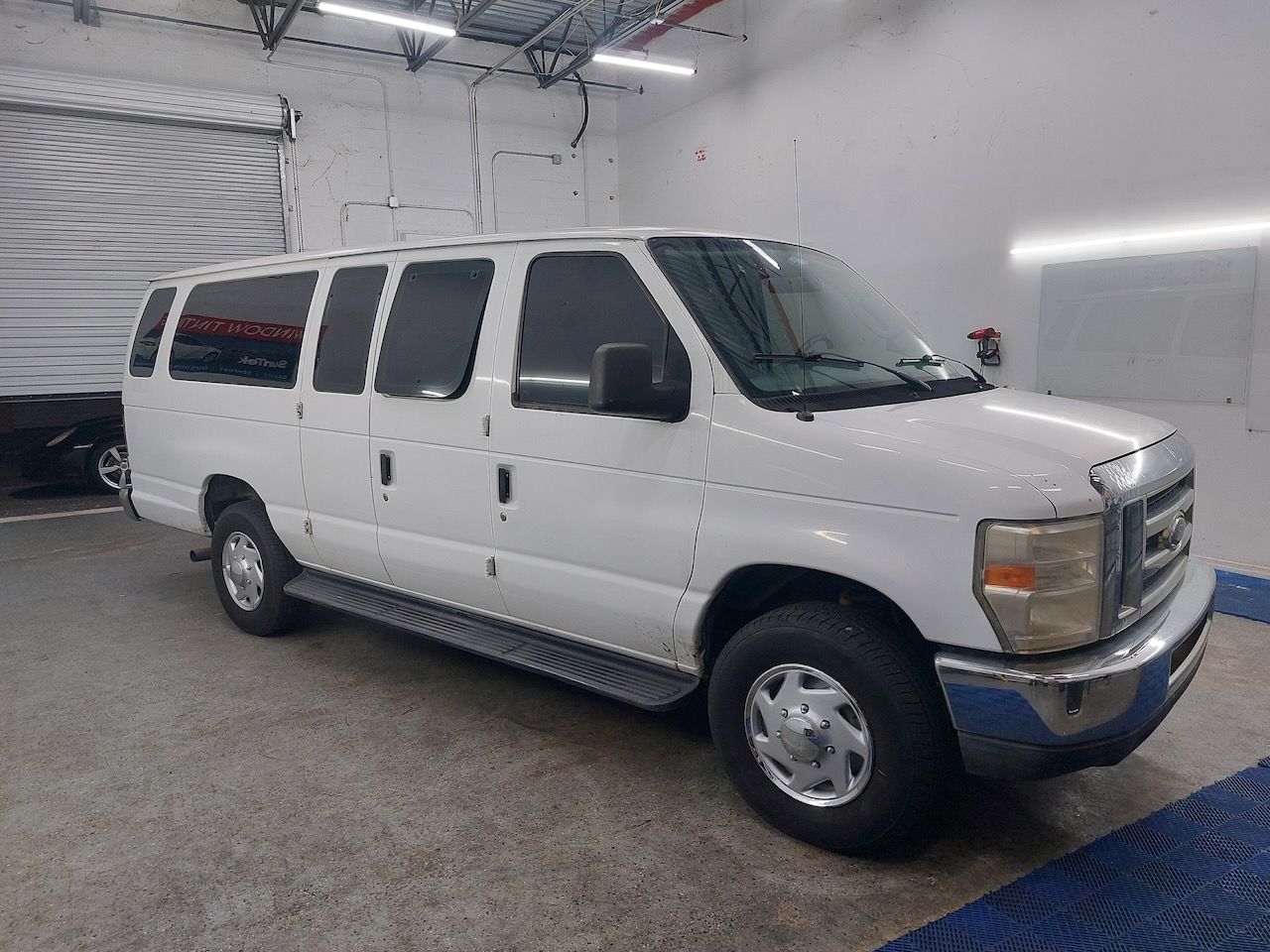 A white van is parked in a garage.