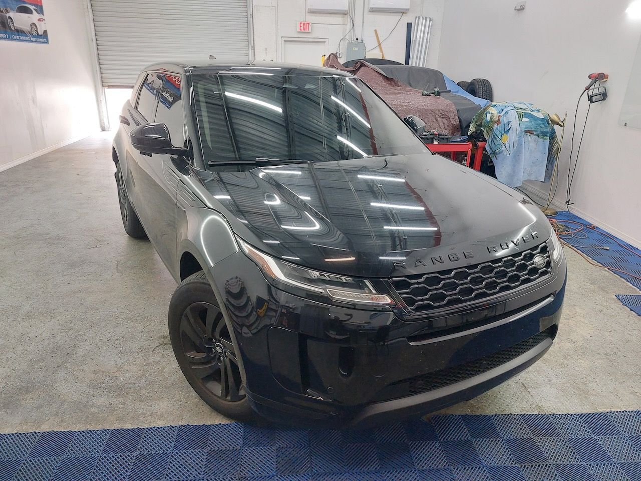 A black range rover evoque is parked in a garage.
