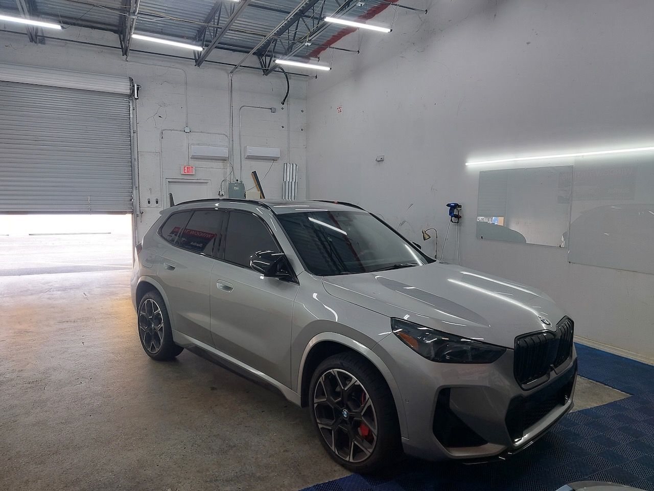 A white bmw x5 m is parked in a garage.