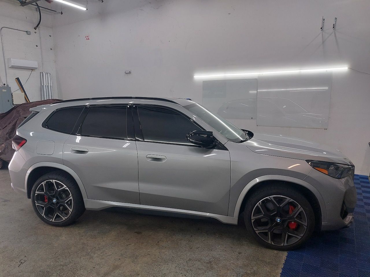 A silver suv is parked in a garage.