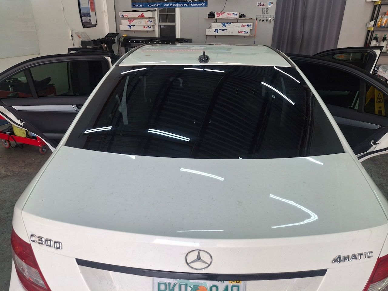 The back of a white mercedes with the doors open