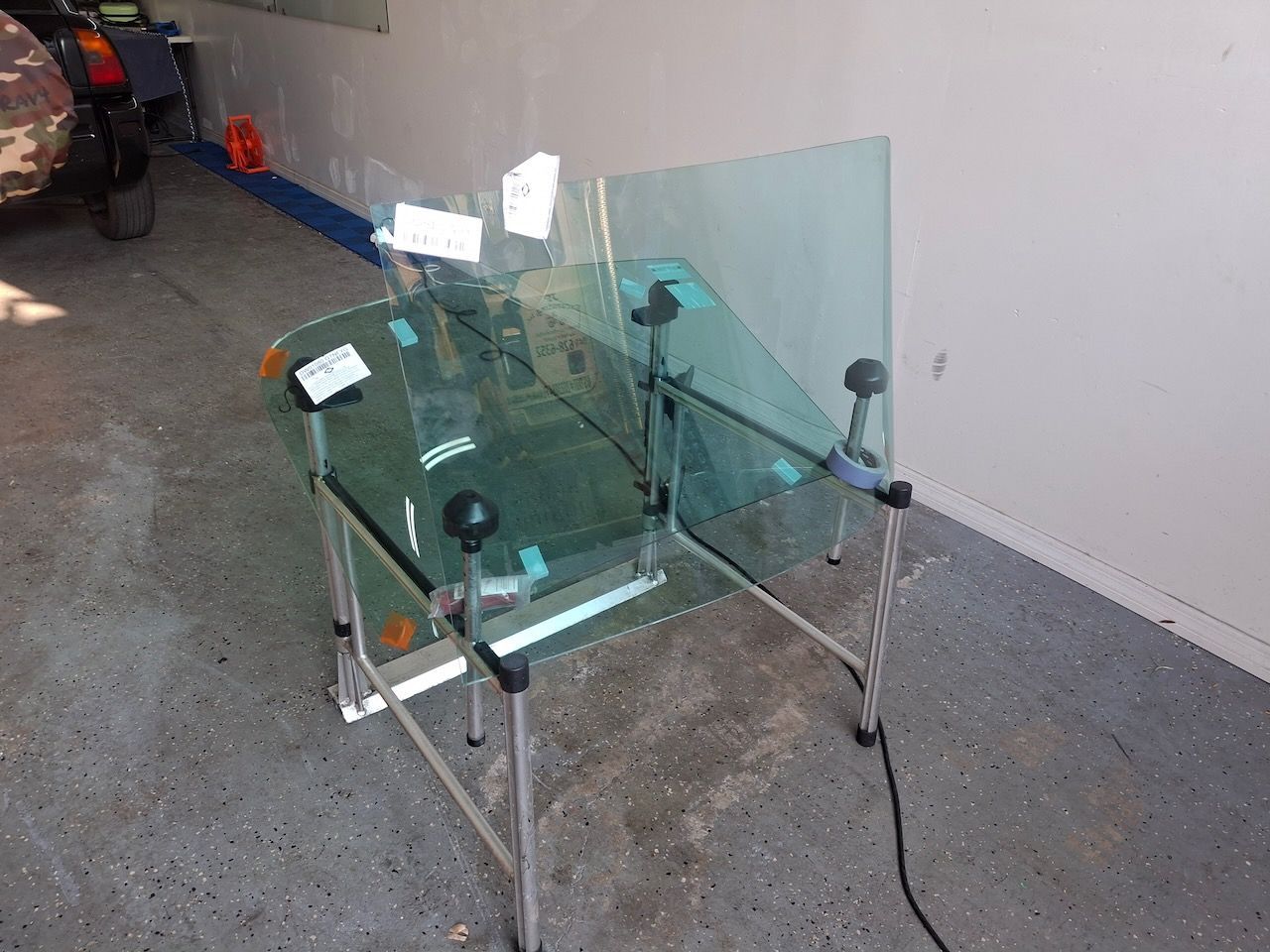 A piece of glass is sitting on a stand in a garage.