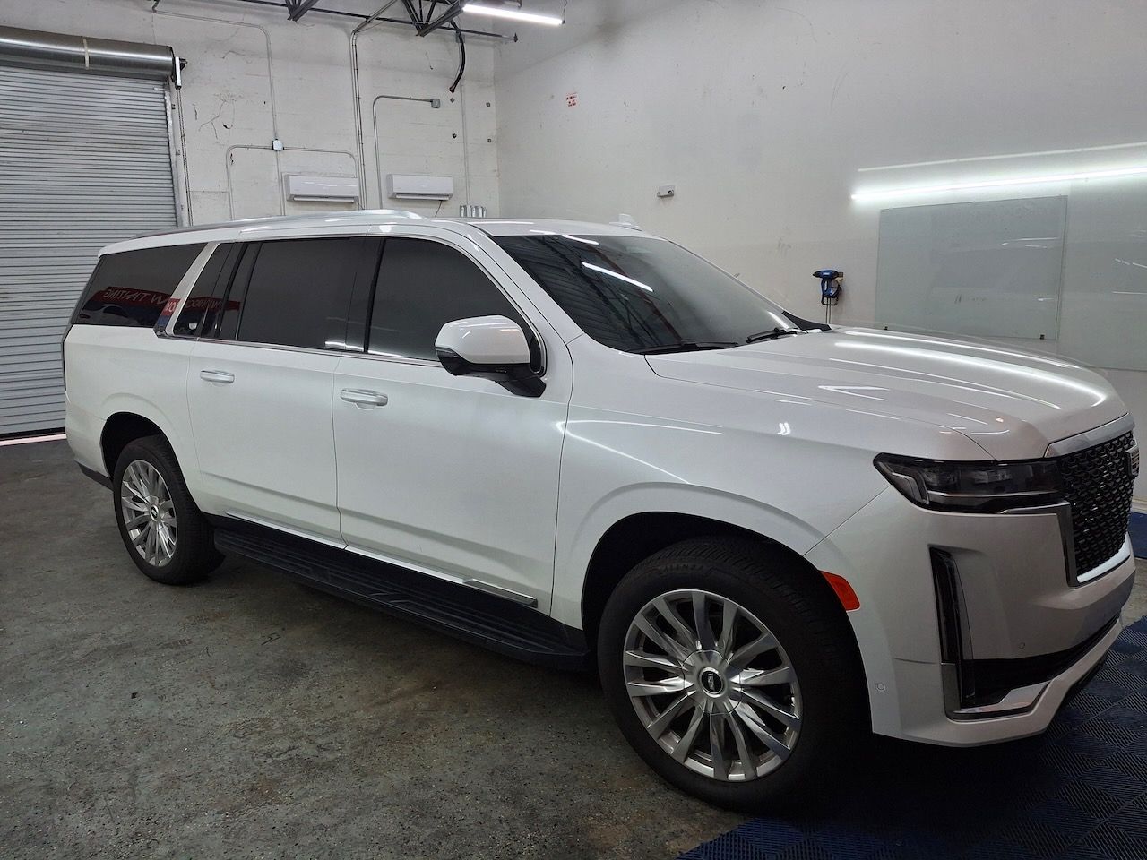 A white suv is parked in a garage.