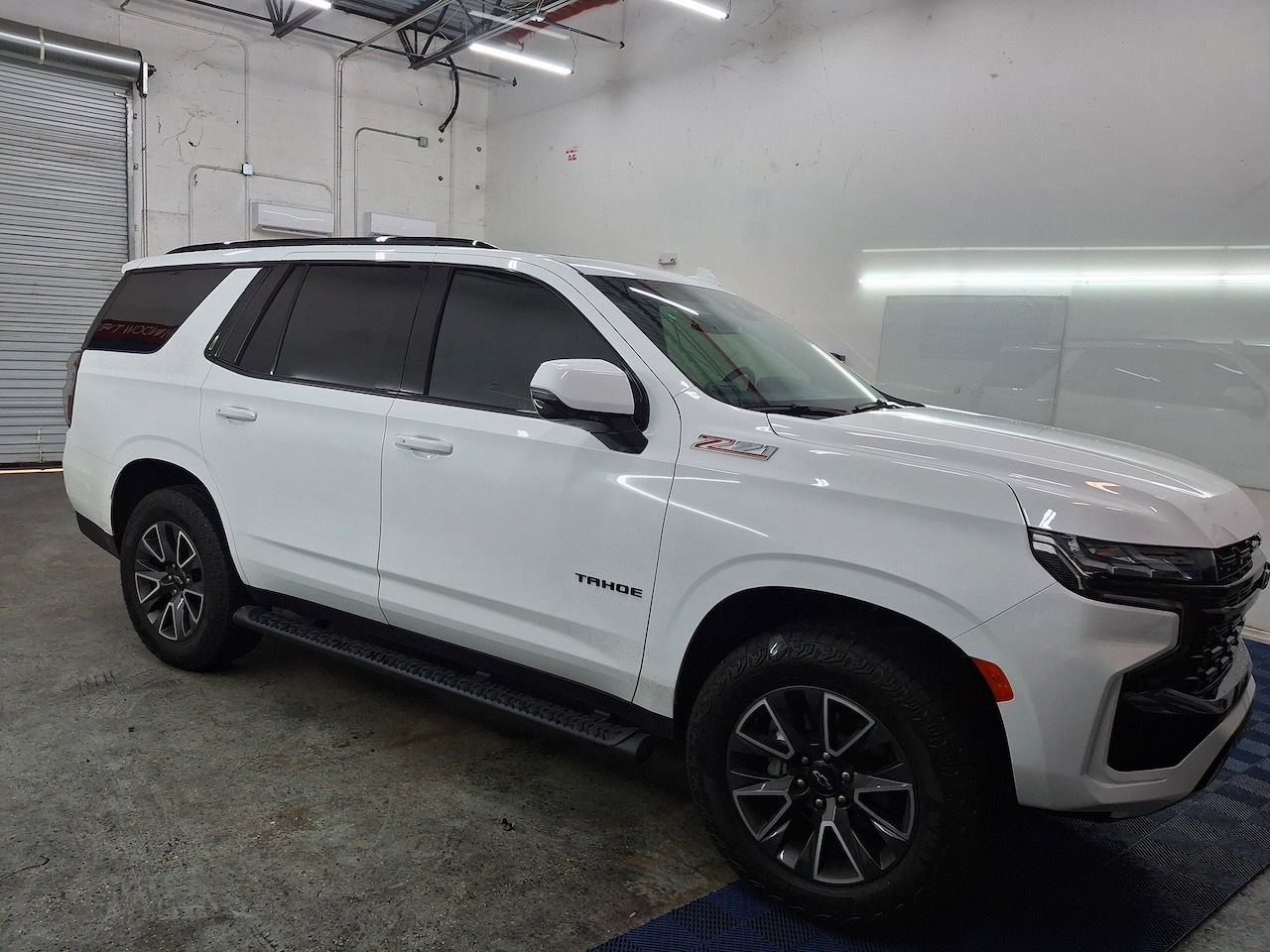 A white suv is parked in a garage.