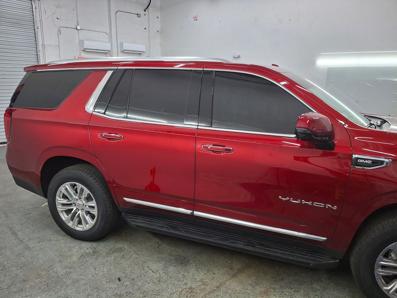 A red suv is parked in a garage.