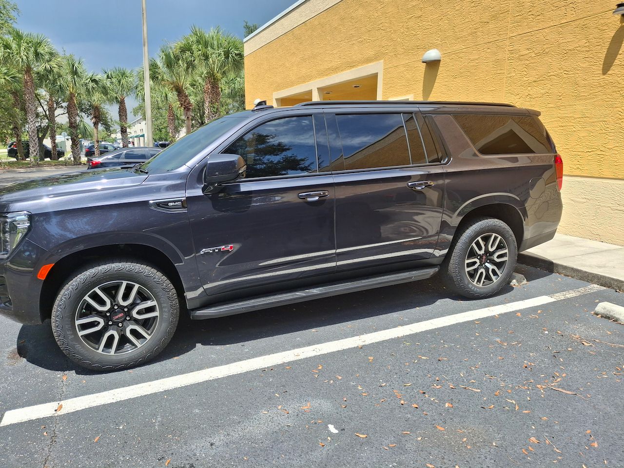 A black suv is parked in a parking lot in front of a building.