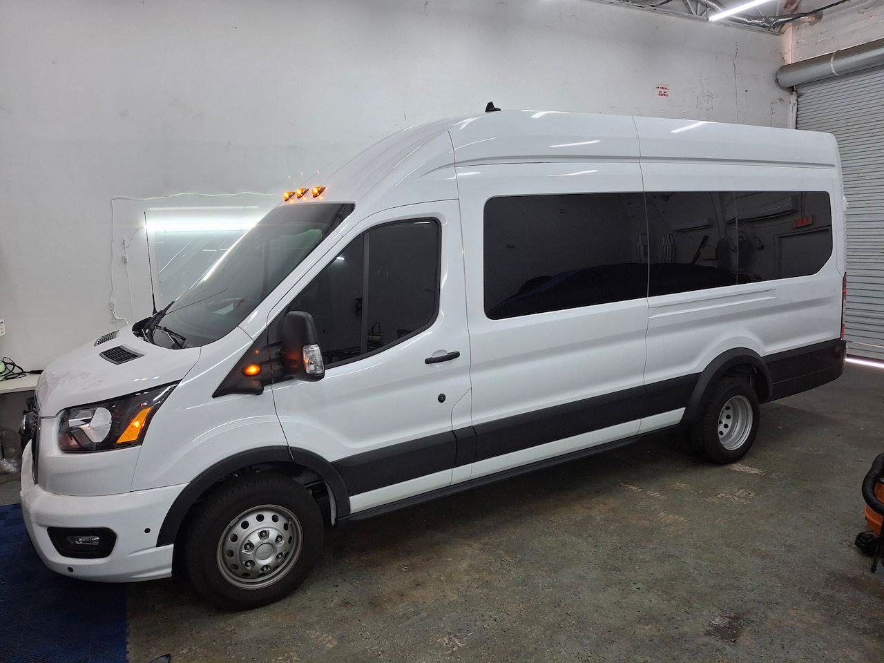 A white van is parked in a garage.