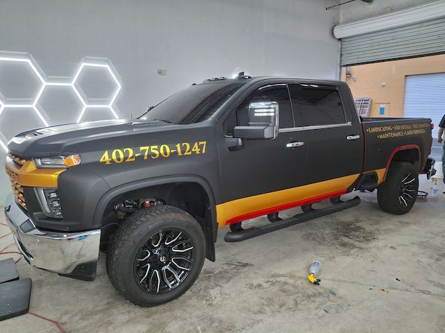 A black and gold truck is parked in a garage.