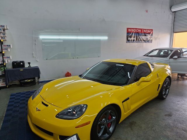 A yellow sports car is parked in a garage