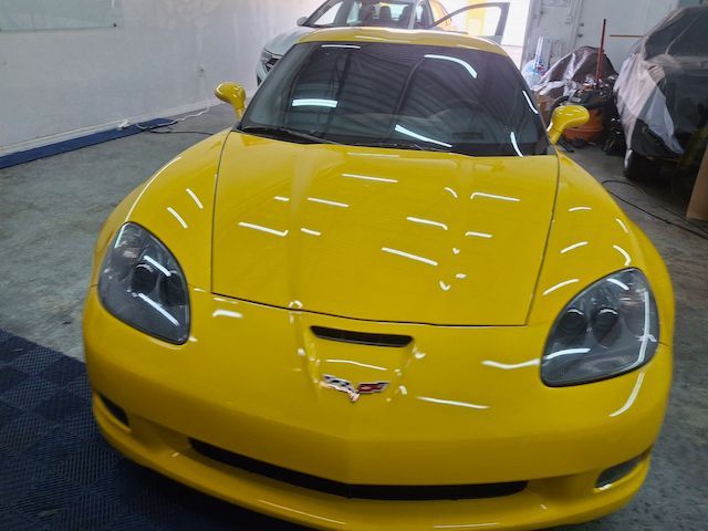 A yellow sports car is parked in a garage