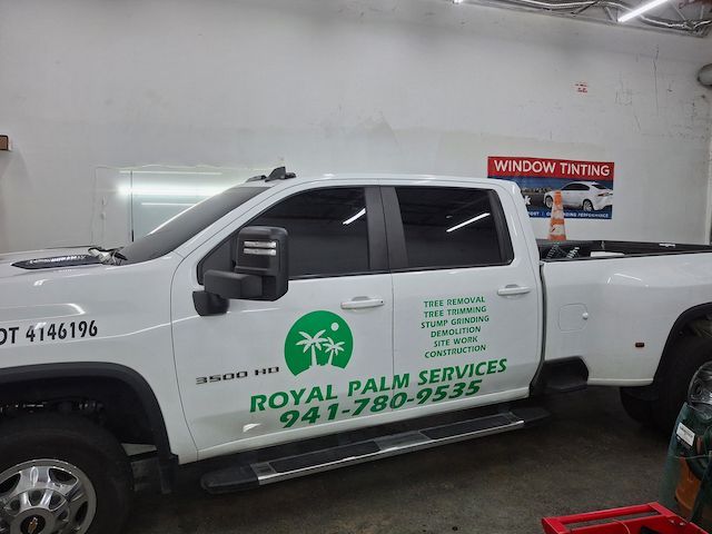 A white truck that says royal palm services on it