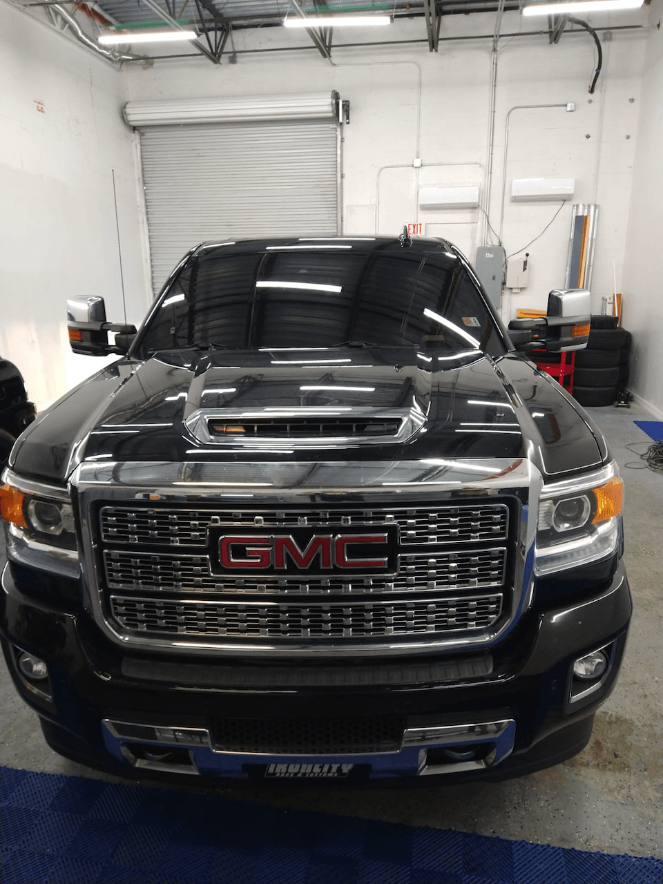 A black gmc truck is parked in a garage.