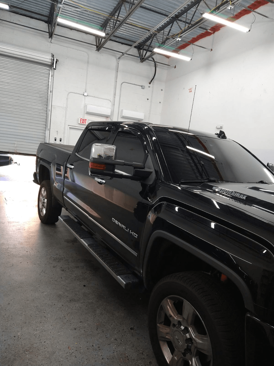 A black pickup truck is parked in a garage