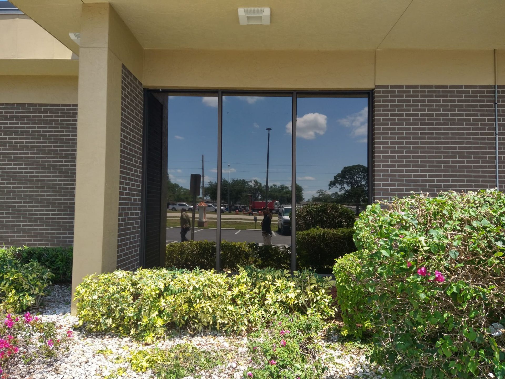 A building with a lot of windows and bushes in front of it