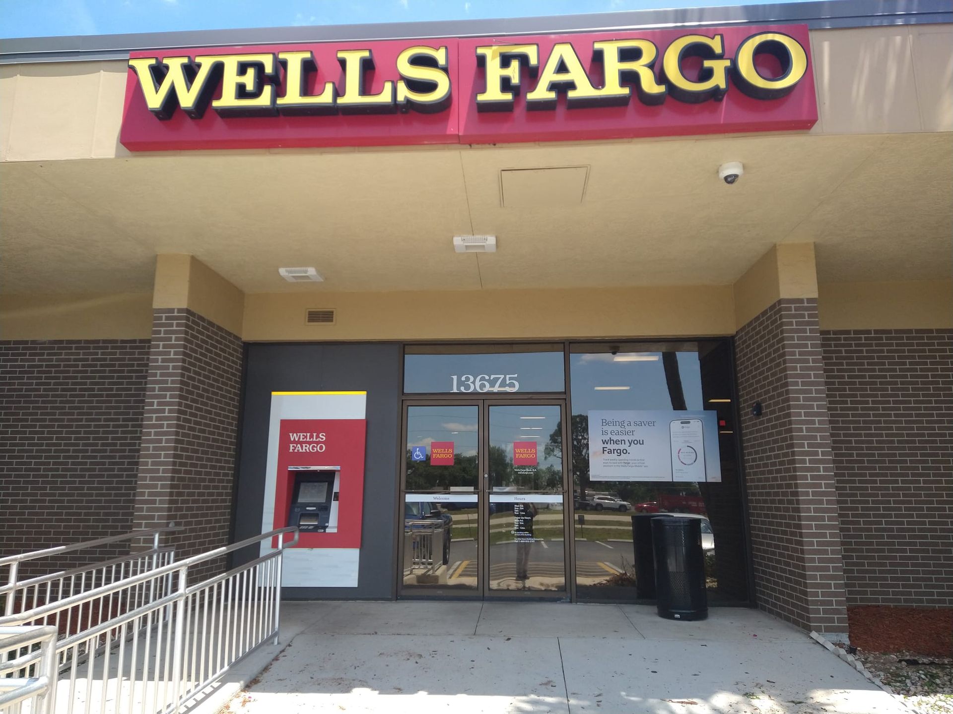 A wells fargo bank with an atm in front of it