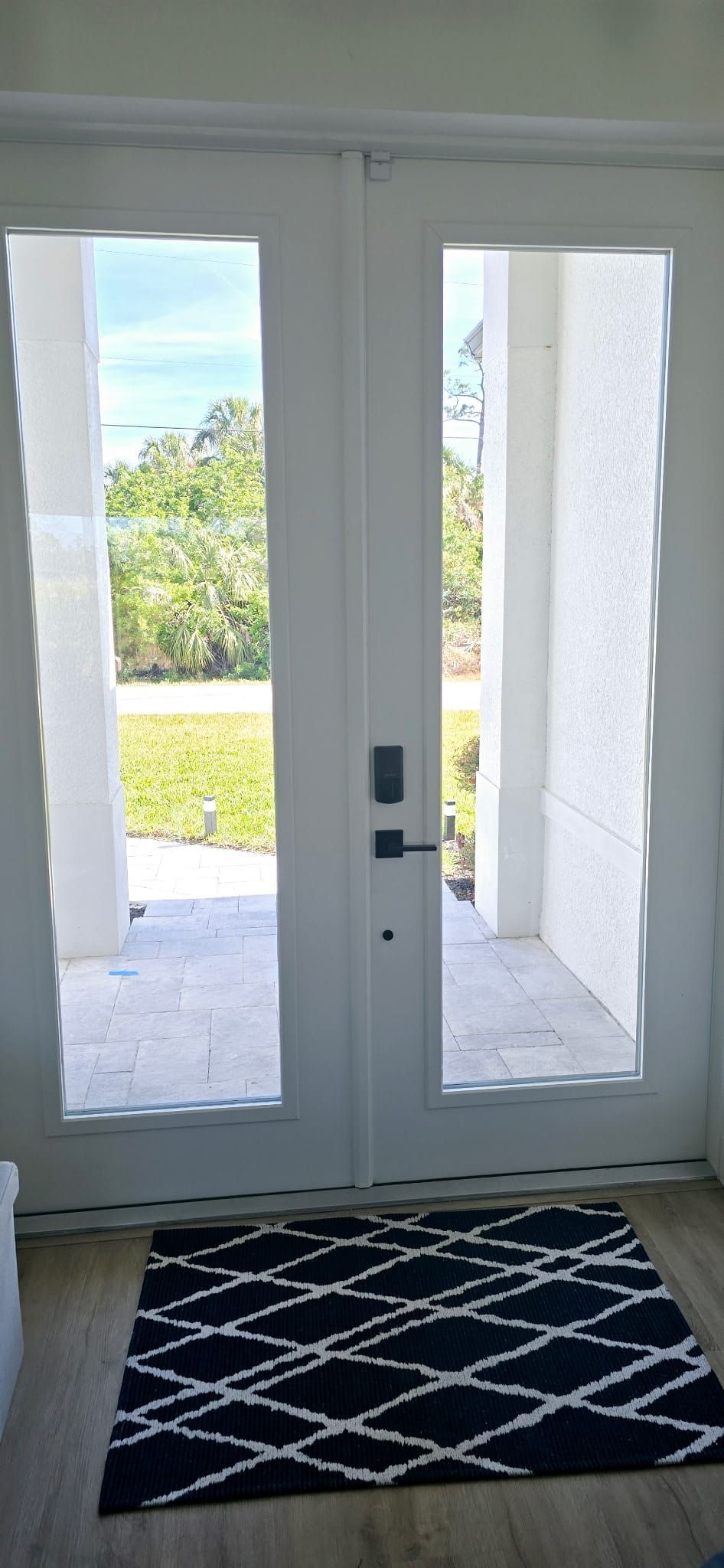 A white door with a black and white rug in front of it.