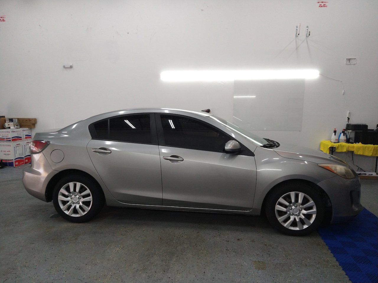 A silver car is parked in a garage.