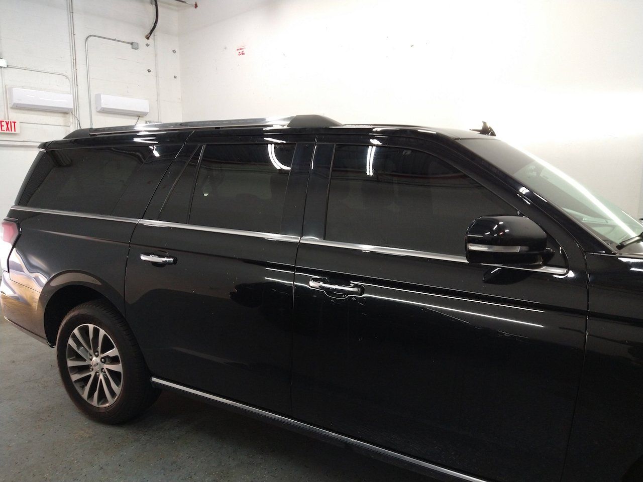 A black suv with tinted windows is parked in a garage.