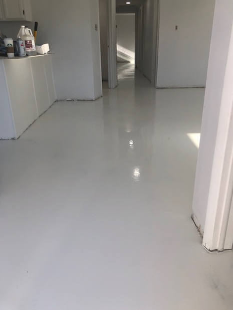 A kitchen with a white floor and white cabinets.