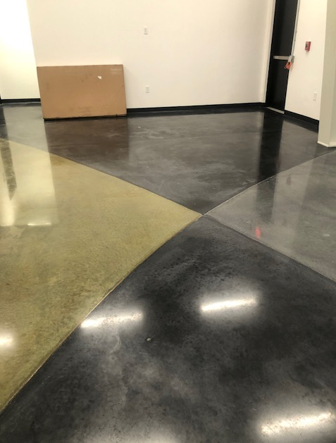 A room with a concrete floor and a wooden box on the wall.