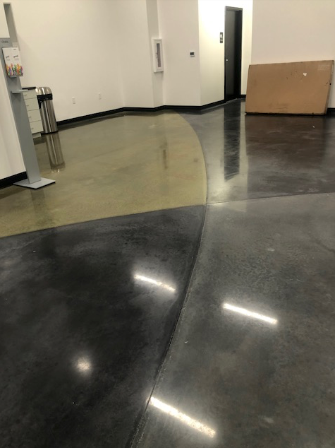 A room with a shiny concrete floor and a cardboard box on the floor