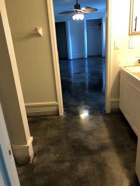 A hallway with a ceiling fan and a sink in a house.