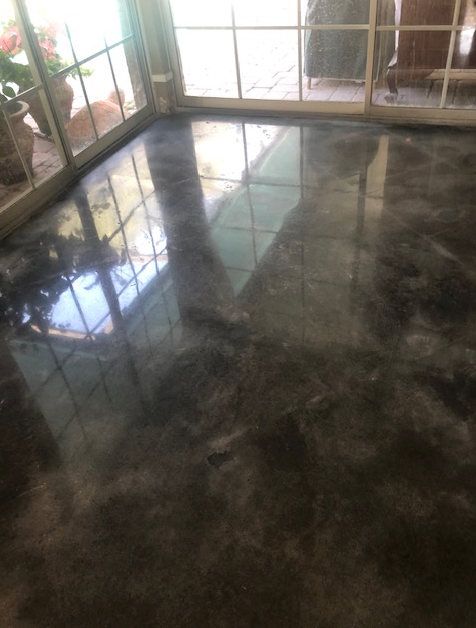 A room with a marble floor and a sliding glass door