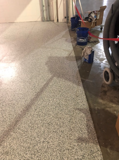 A mop is sitting on the floor next to a vacuum cleaner.