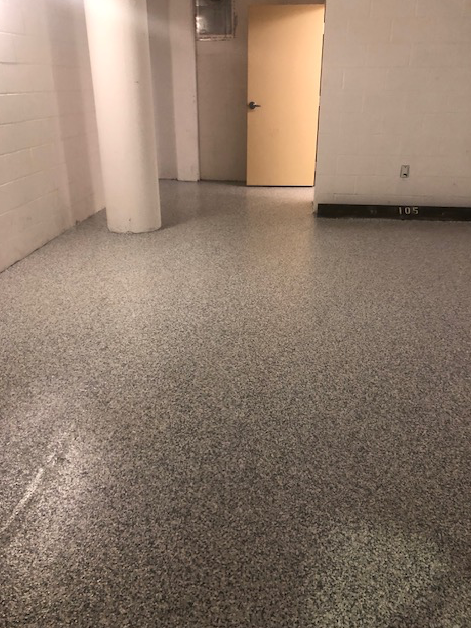 A room with a concrete floor and a door.