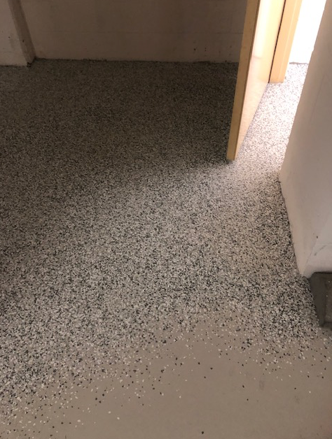 A room with a gray and white floor and a door.