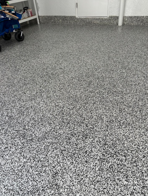 A gray and white floor with a blue wagon in the background.