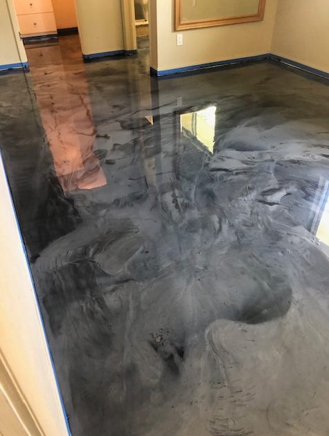 A room with a shiny metallic floor and a mirror.