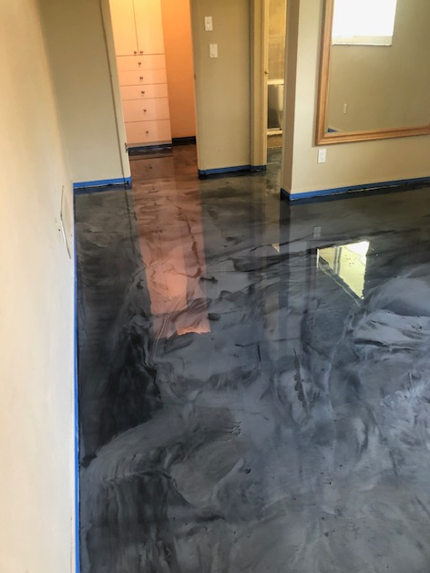 A living room with a shiny metallic floor and a mirror.