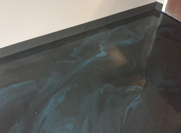 A close up of a black and blue floor in a room.