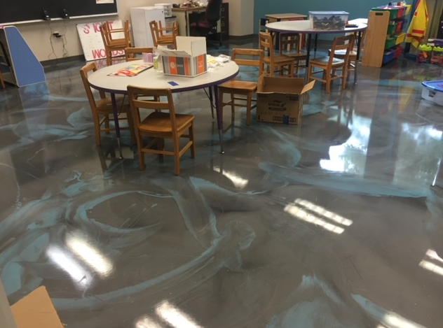 A classroom with tables and chairs and a shiny floor