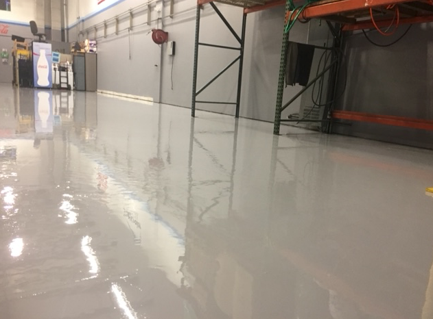 A warehouse with a shiny floor and a lot of shelves.