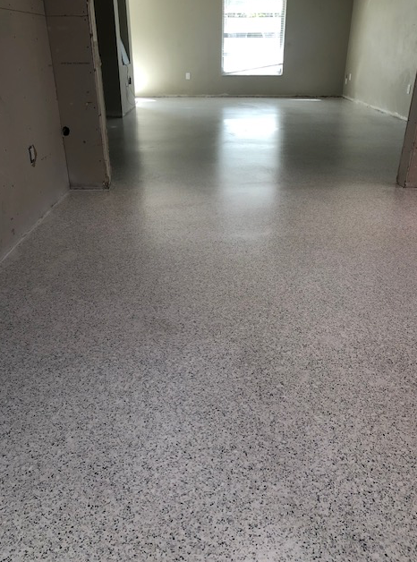 A living room with a white floor and a window.