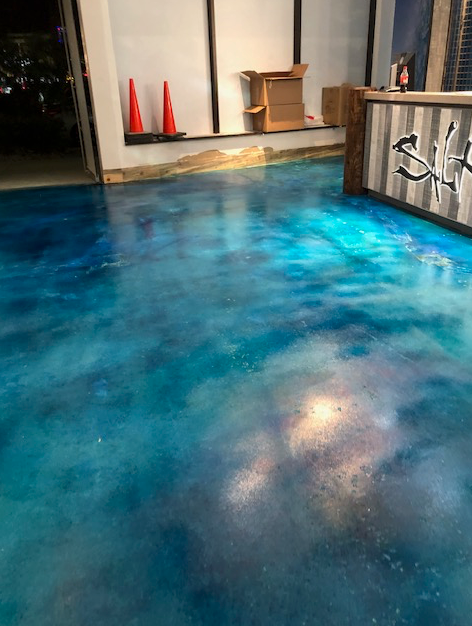 A blue concrete floor with a galaxy design in a room.