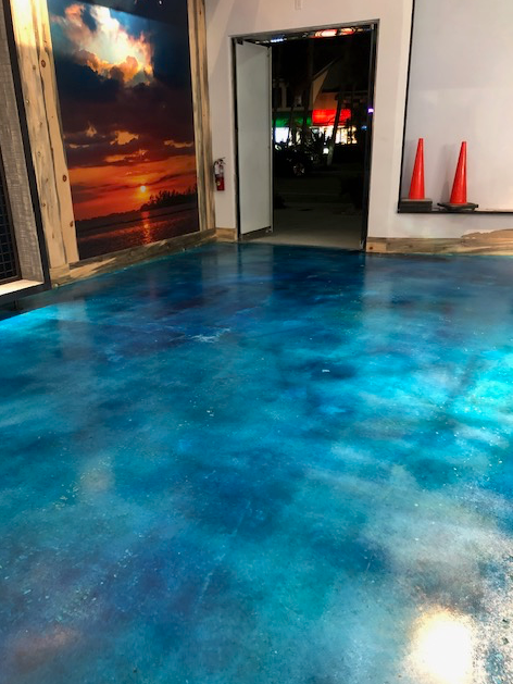 A room with a blue floor and a picture on the wall.