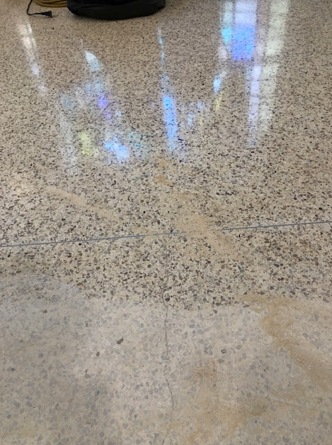 A close up of a marble floor with a vacuum cleaner on it.