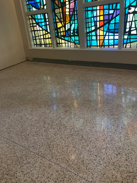 A room with a stained glass window on the wall