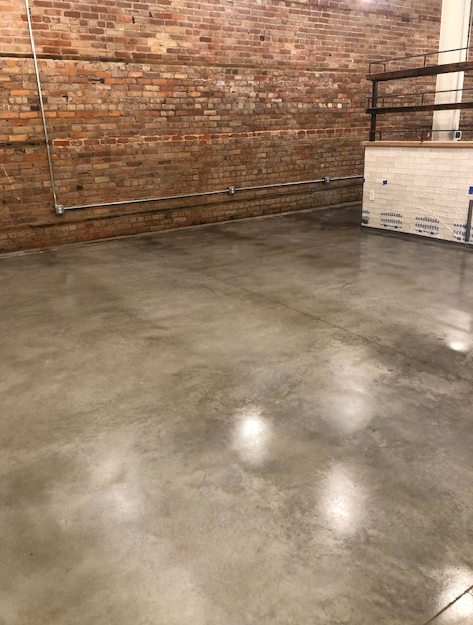 A room with a brick wall and a concrete floor.