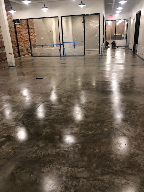 A large room with a concrete floor and a lot of windows.